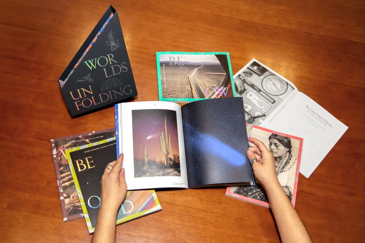 two hands hold open one paperback unit of a multi-book box set