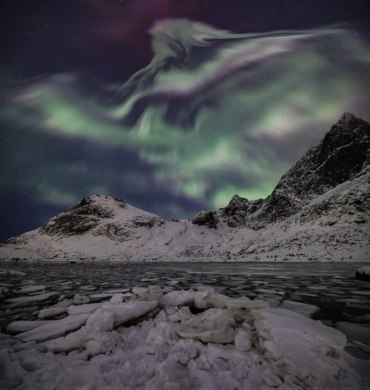an astronomy photo of aurora borealis over a remote Norway landscape