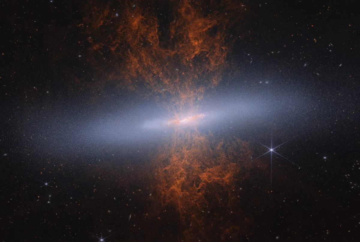an image of an orange galaxy with a light through it