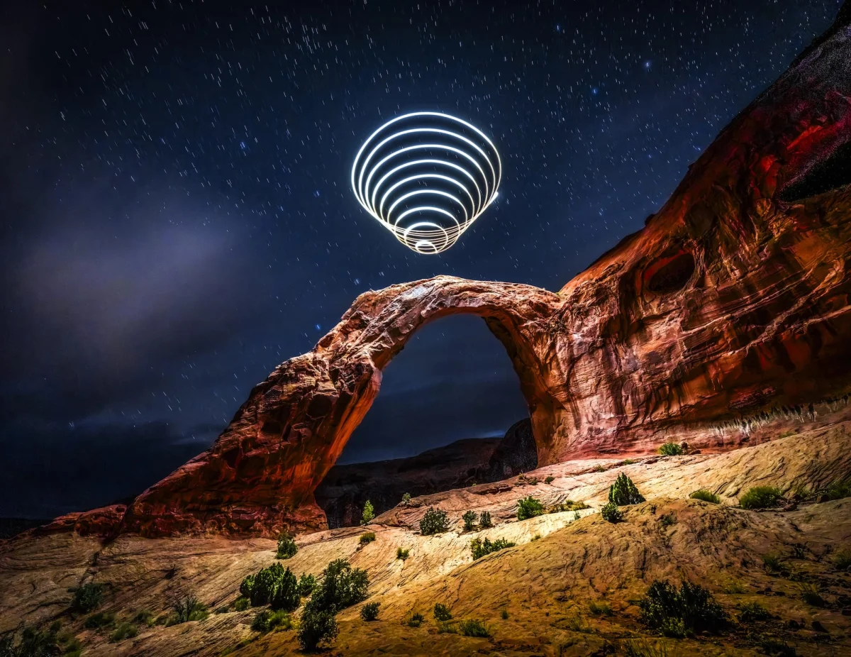 a "light painting" photograph with a cone of swirling light, created using a drone, over a dramatically lit nighttime desert landscape